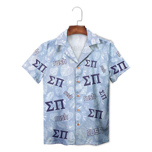 Light blue fraternity shirt featuring navy Greek letters and tropical foliage